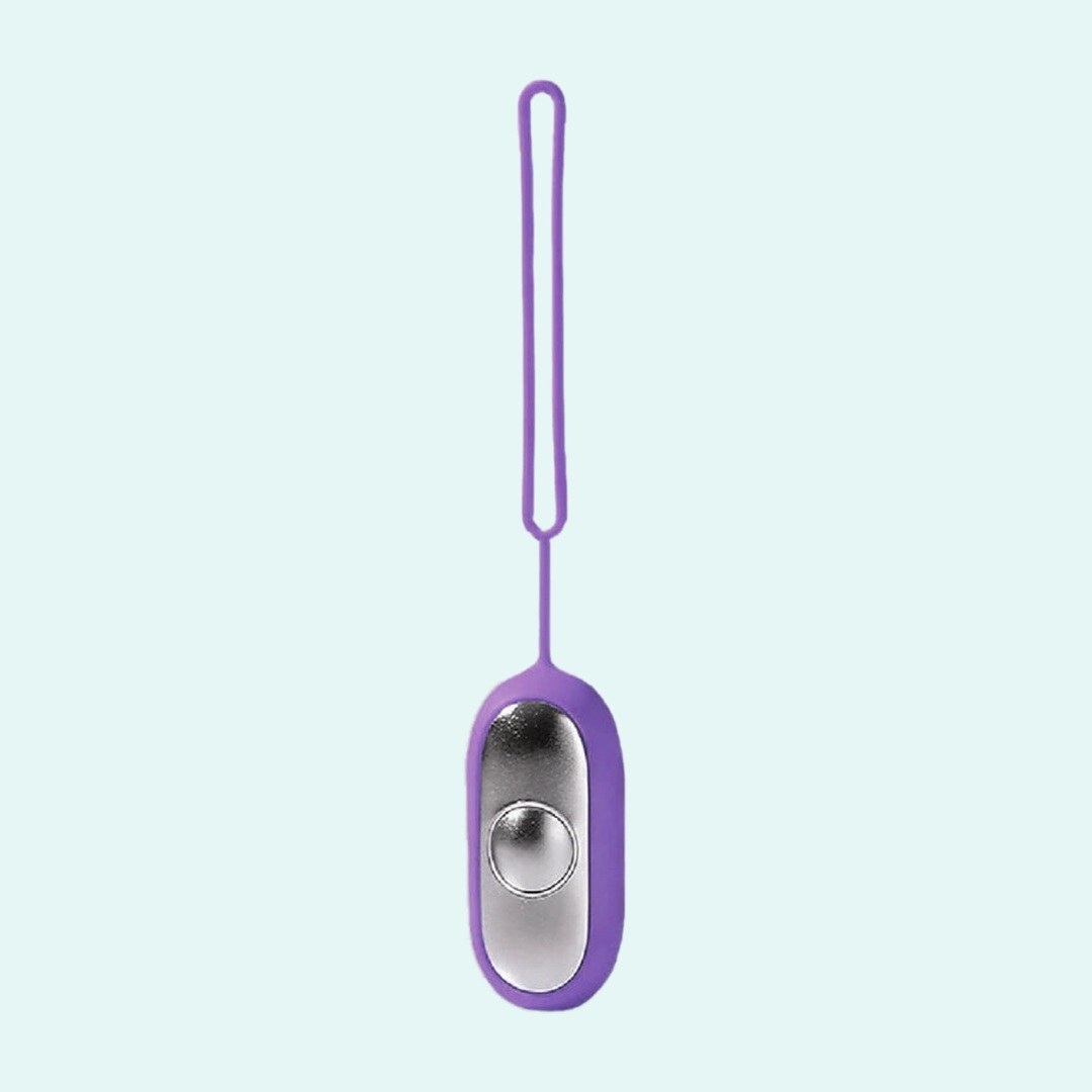 Palm Calm Fidget in Purple: mirror polished silver faceplate, one domed button, purple silicone shell and loop