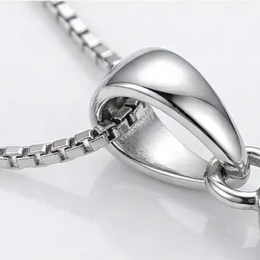 Macro view of the teardrop bail and the fine silver tone box link chain