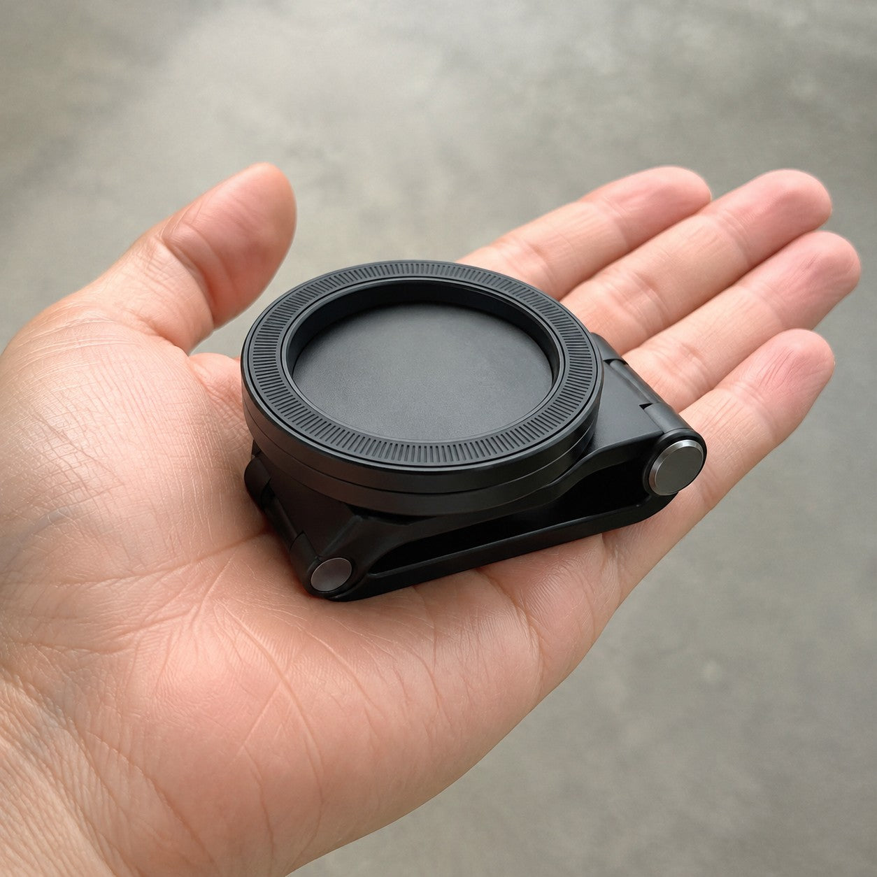 The Magnetic Car Phone Mount folded flat in a hand