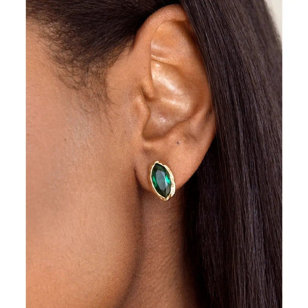 The Pomence Crystal Mini Stud Earrings in emerald crystal, worn close on the ear