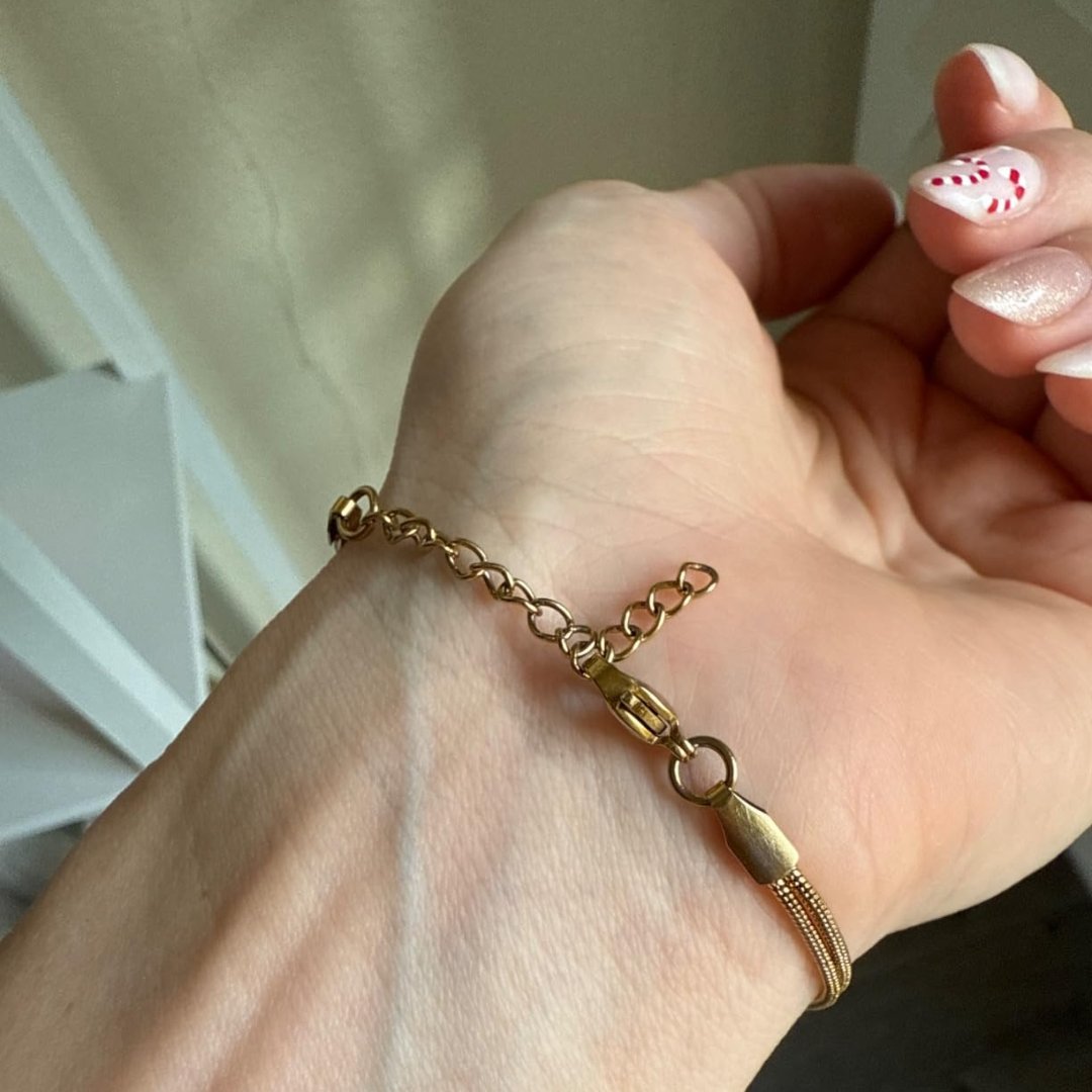 Macro of the lobster clasp, short extender chain and small blank oval tag at the back of the Pomence Forever Knot Bracelet