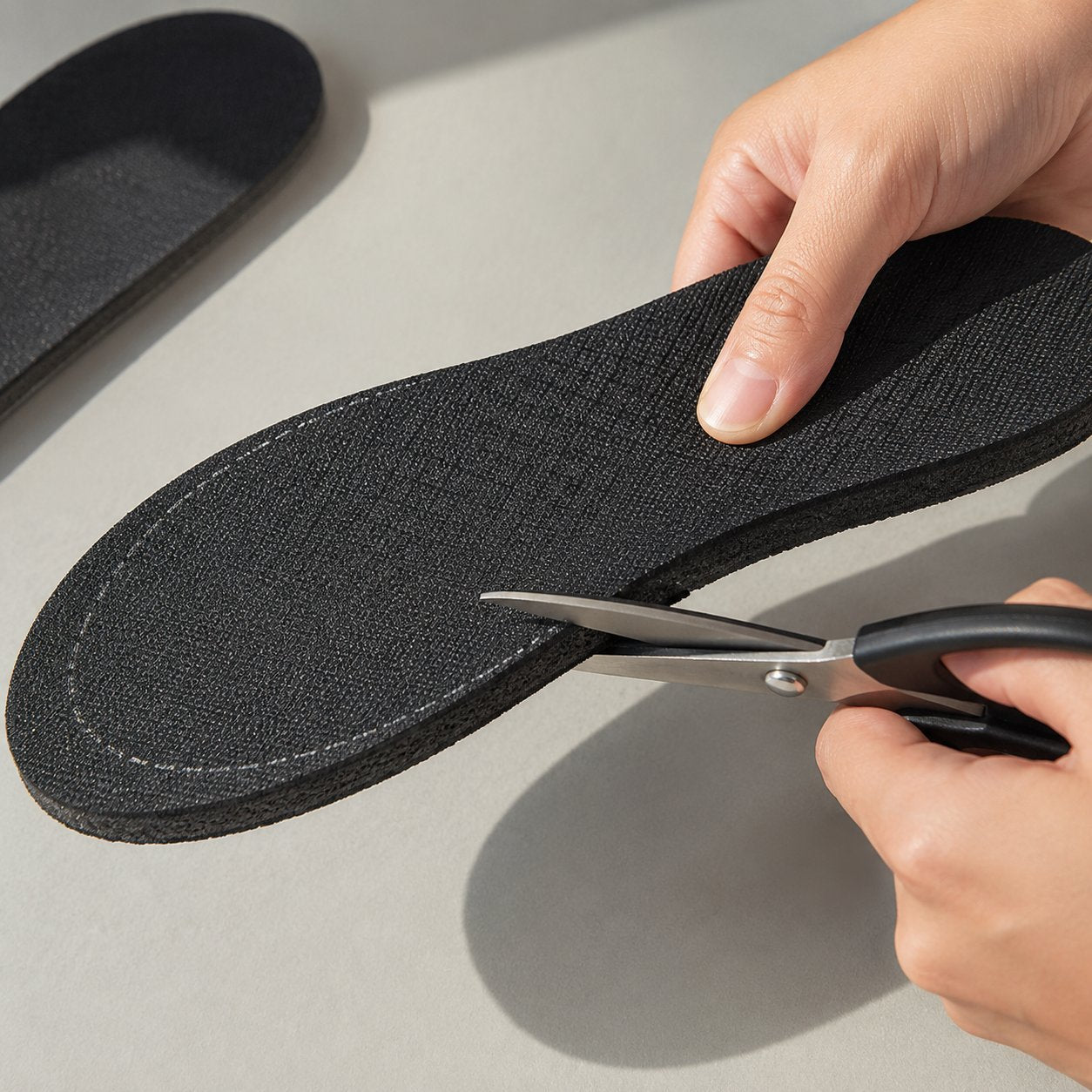 Trimming a Pomence Height Boost Insole along its marked size line