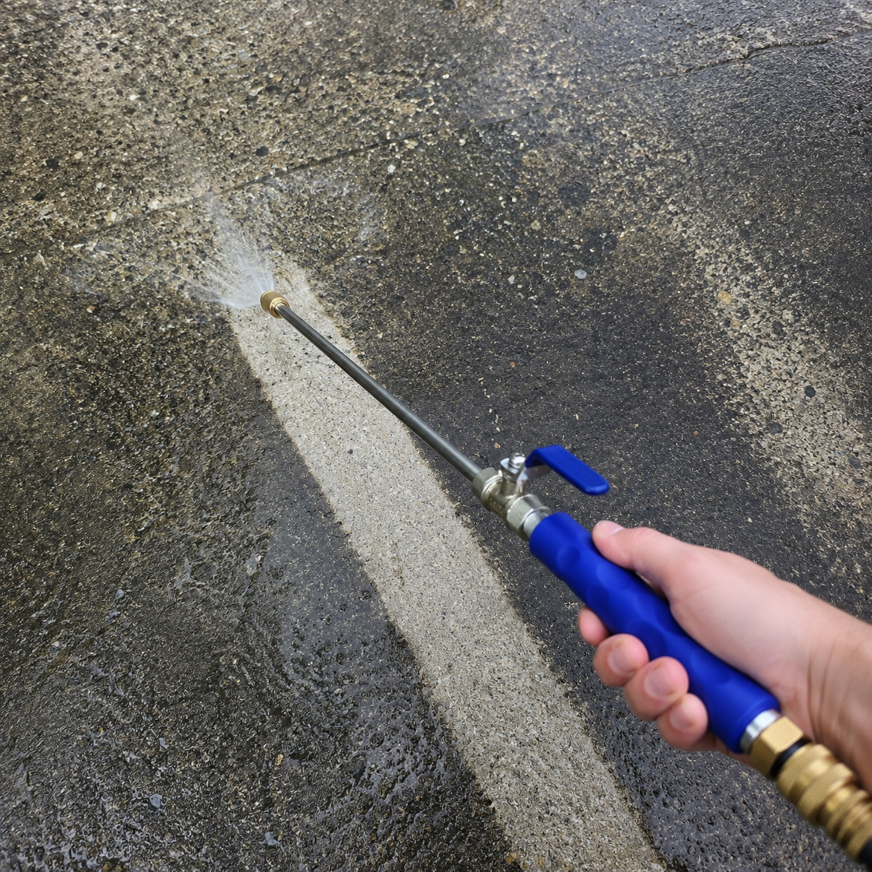 JetHose stripping black grime off a concrete driveway