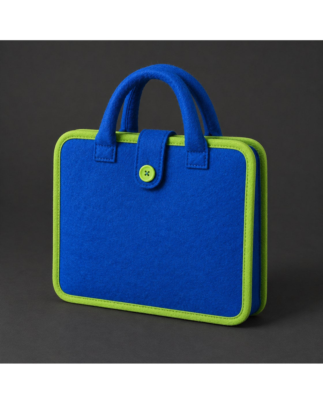 The Pomence Montessori Busy Board closed in a front three-quarter view on a dark charcoal background, its felt tab and button closure on the front panel