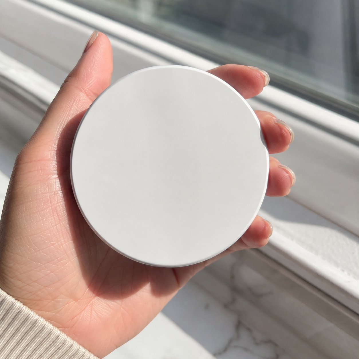 Hand holding the closed Pomence round lash case