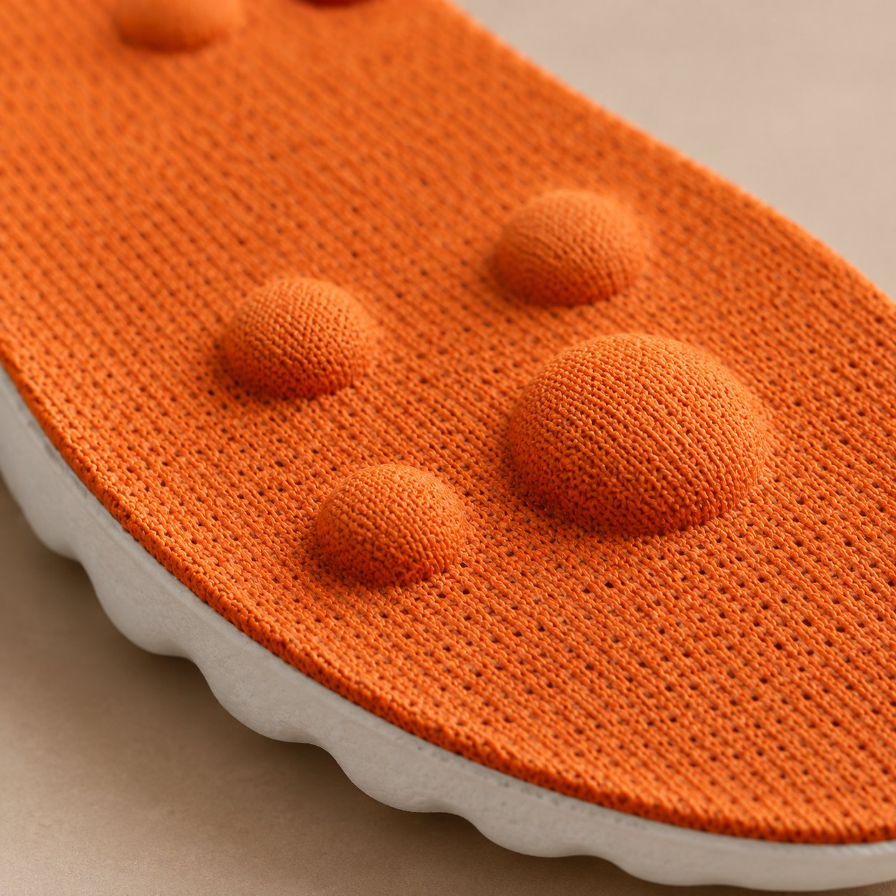 Close-up of the seven raised massage nodes molded into the knit top deck of the Pomence Massage Insoles