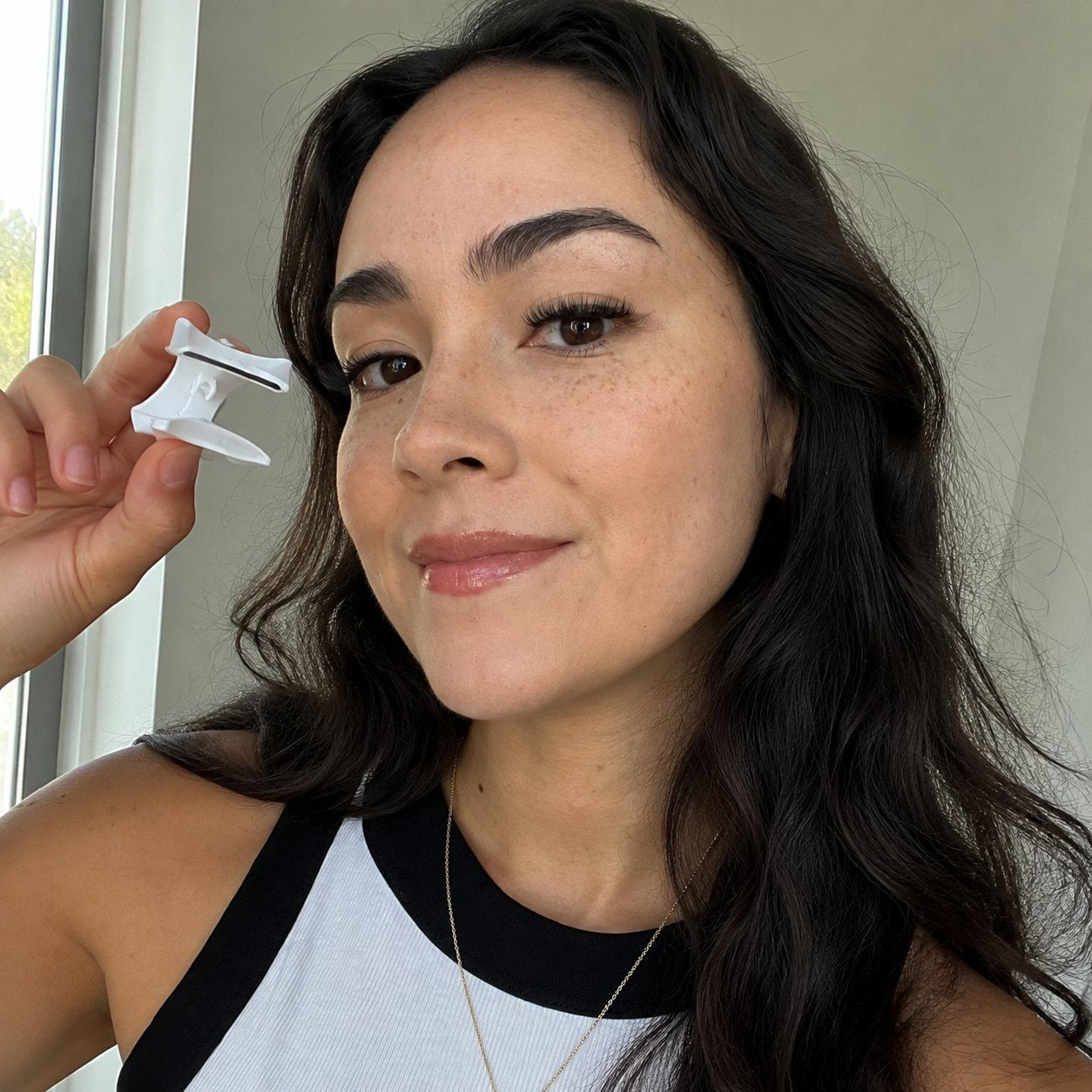 Woman holding the Pomence magnetic lash applicator