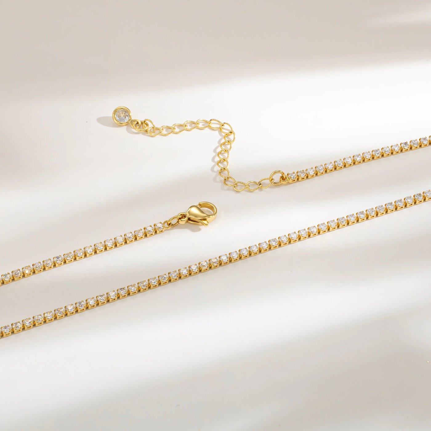 The lobster clasp and the 2 inch extender chain of the Pomence Tennis Necklace, ending in a tiny bezel set round stone