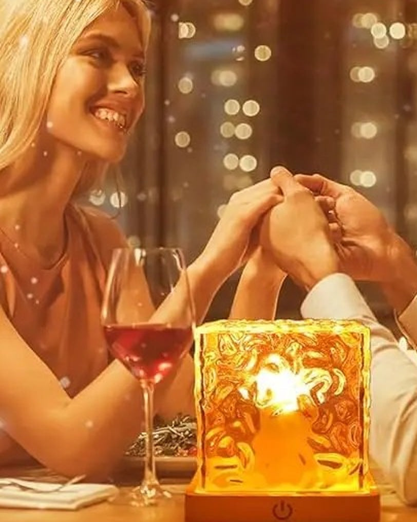 The cube lamp glowing warm orange on a dinner table
