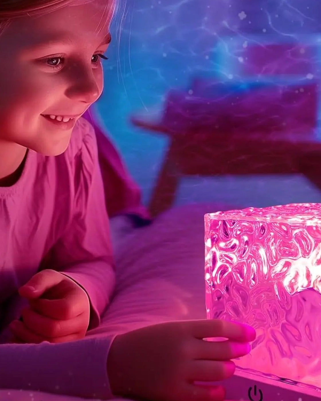 A child in bed watching the cube lamp glow bright pink