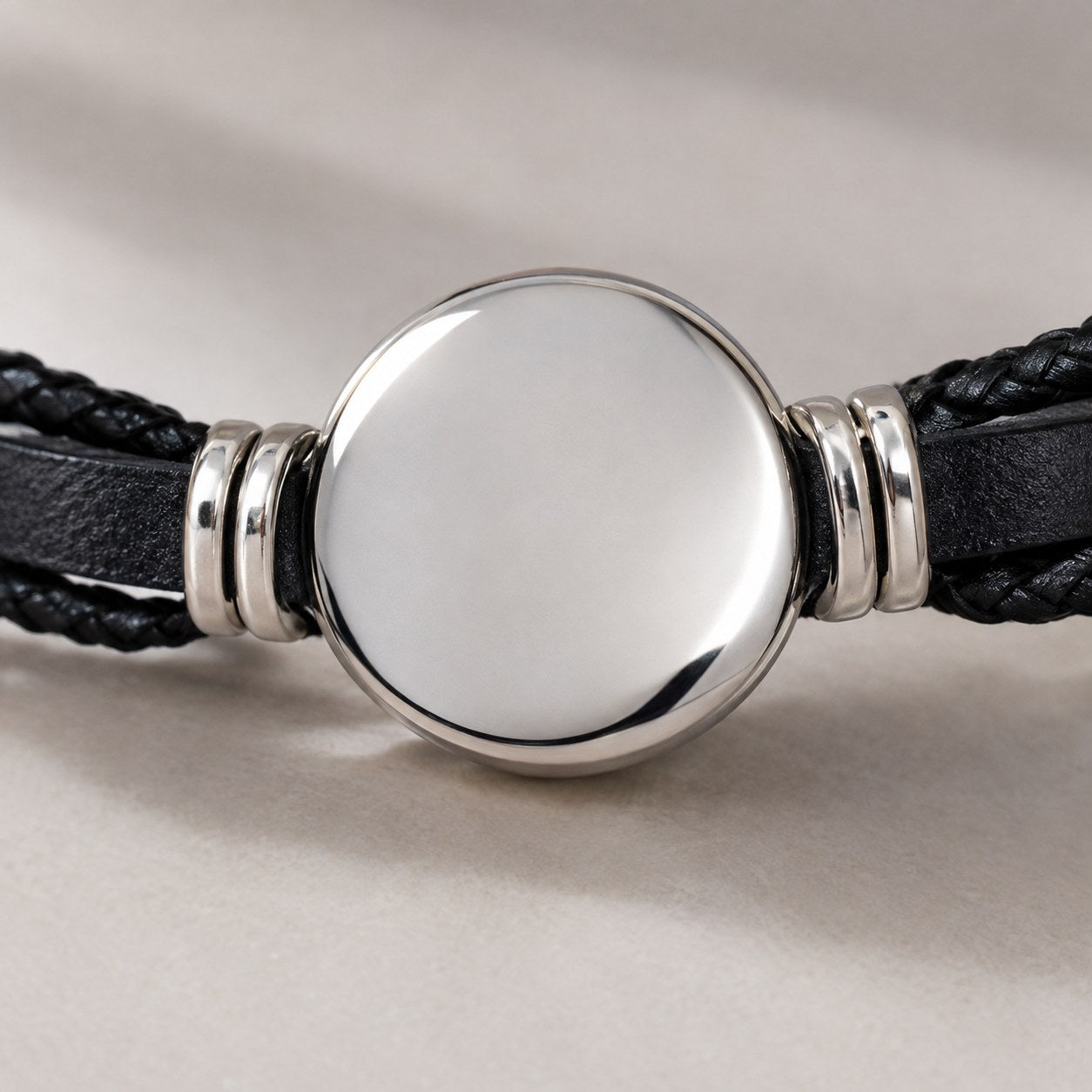The plain polished silver-tone back of the zodiac dome on the Pomence Zodiac Leather Bracelet