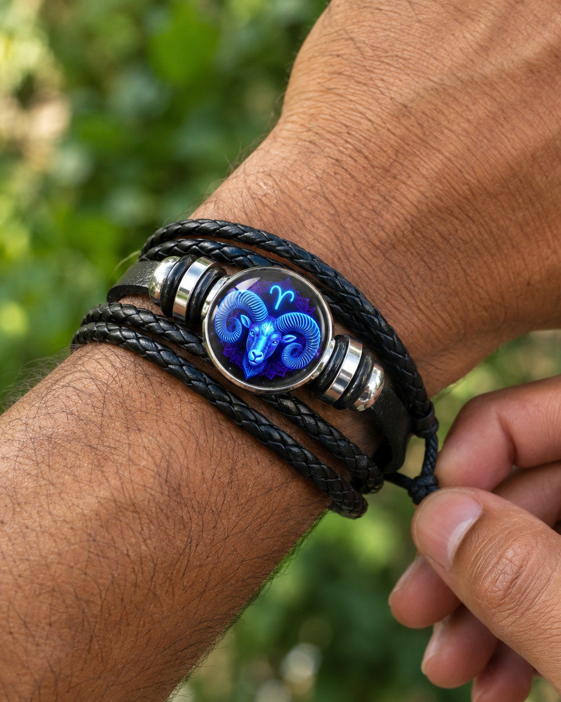 A man fastening the Pomence Zodiac Leather Bracelet on his wrist outdoors