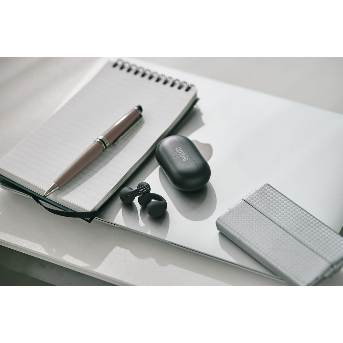 Ambie Sound Earcuffs AM-TW02. Ambie earcuffs and case on a desk