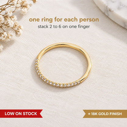 Pomence Birthstone Stacking Ring shown as a flat lay, a thin yellow gold tone band with one row of tiny colored stones