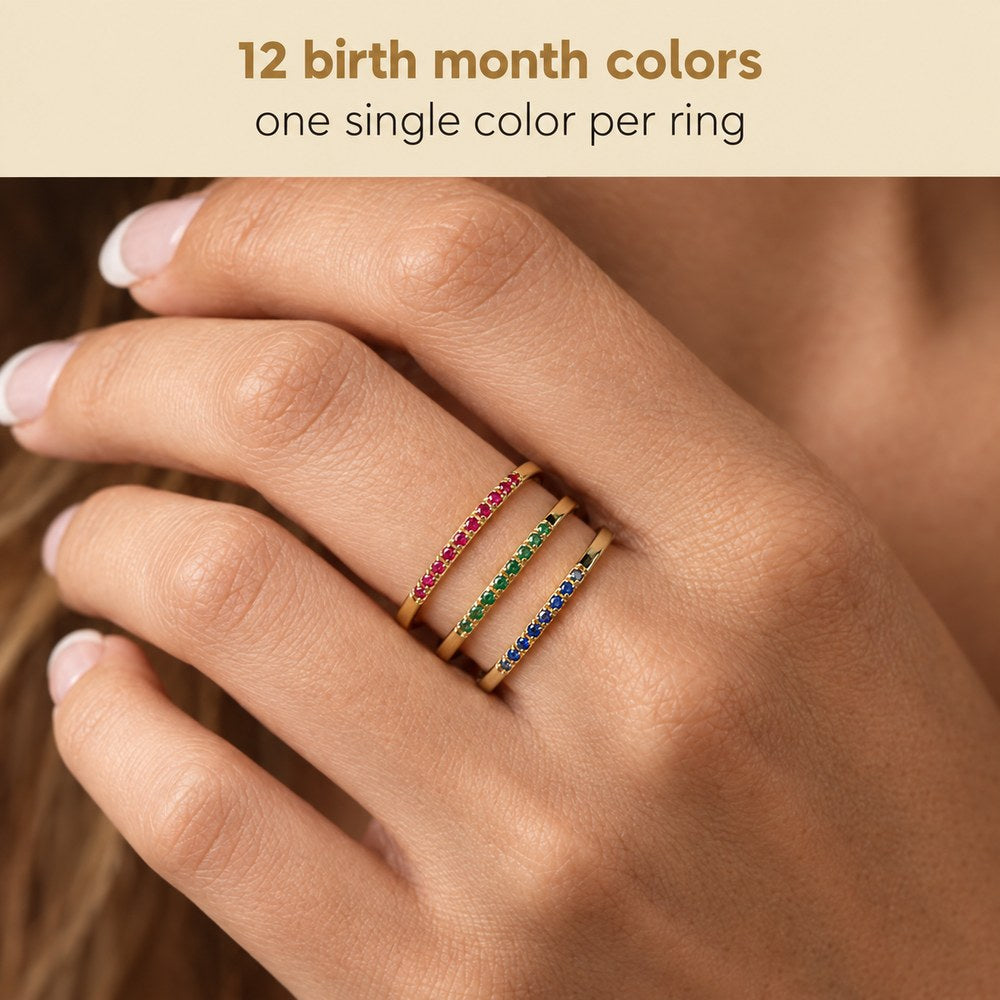 Macro view of a hand wearing three Pomence Birthstone Stacking Rings, one row of tiny stones on each band