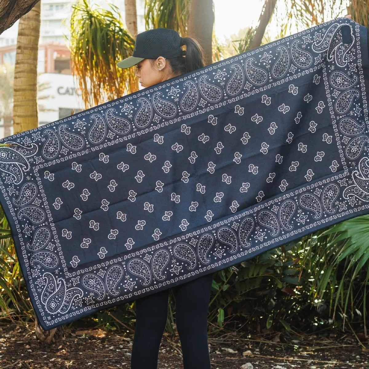 A woman holding the Pomence Car Seat Cover Towel open to show its full length