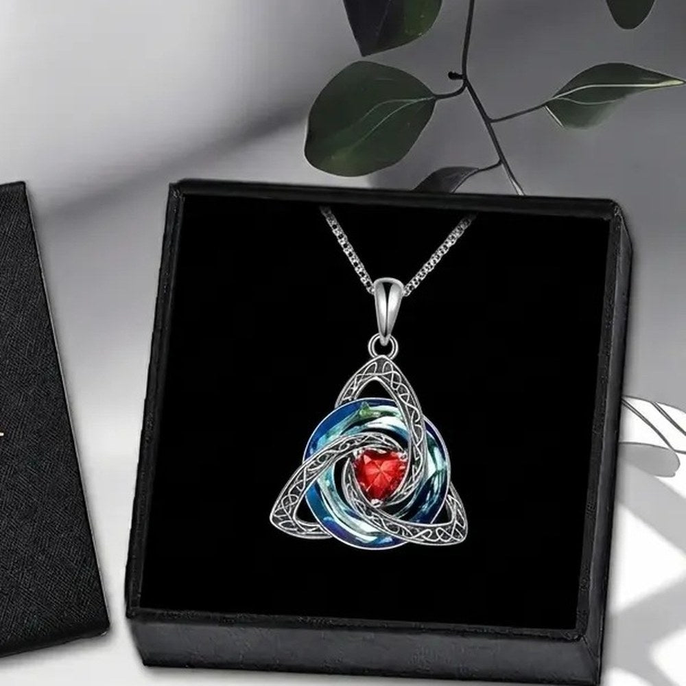 The Pomence Birthstone Celtic Knot Necklace laid in its plain jewelry box