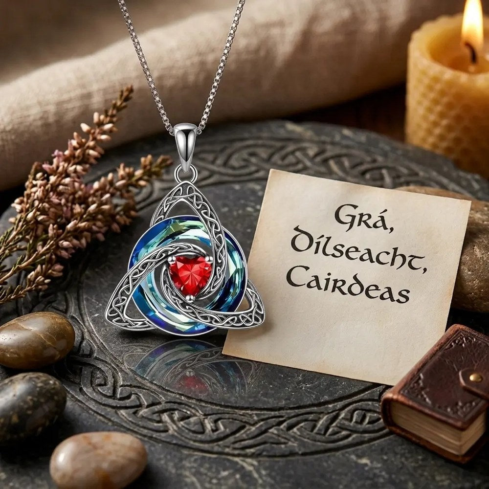 The Pomence Birthstone Celtic Knot Necklace laid on carved slate with heather and a Gaelic card