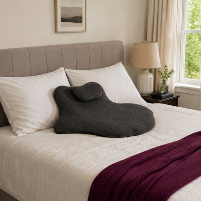 Pomence Couples Comfort Pillow resting among regular pillows on a made bed