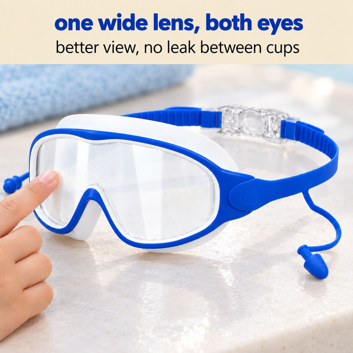 Close view of the Pomence Kids Swim Goggles single wide lens across both eyes with the open nose notch, a fingertip at the lens edge