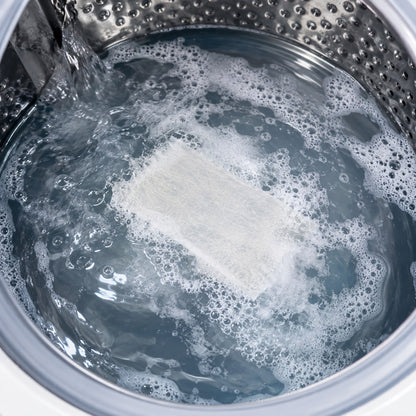 A Pomence Laundry Detergent Sheet dissolving into suds in a washing machine drum