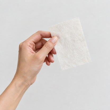 Holding up a single Pomence Laundry Detergent Sheet