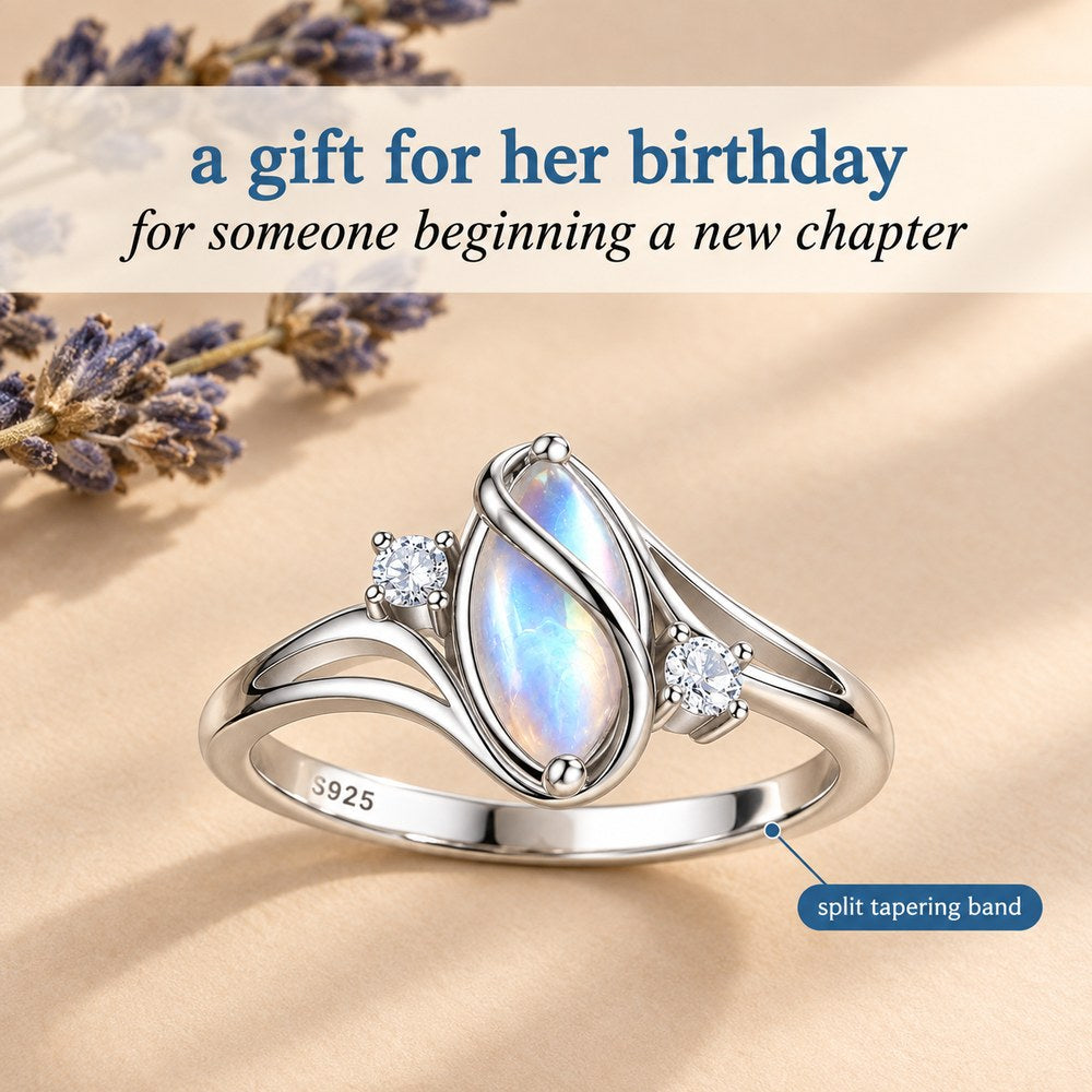 The Pomence Moonstone Ring staged on warm beige with dried lavender, labelled split tapering band