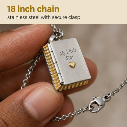 Macro of the Pomence My Little Star Book Locket Necklace held between two fingers, showing the 18 inch chain and its clasp