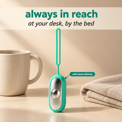 The Teal Palm Calm Fidget standing on a table beside a mug and a folded towel
