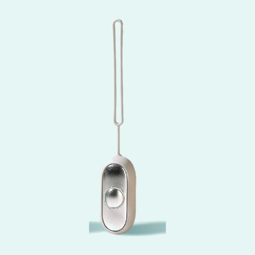 Palm Calm Fidget in Grey: a warm bone silicone shell around the mirror polished silver faceplate and one domed button, silicone loop rising from the top