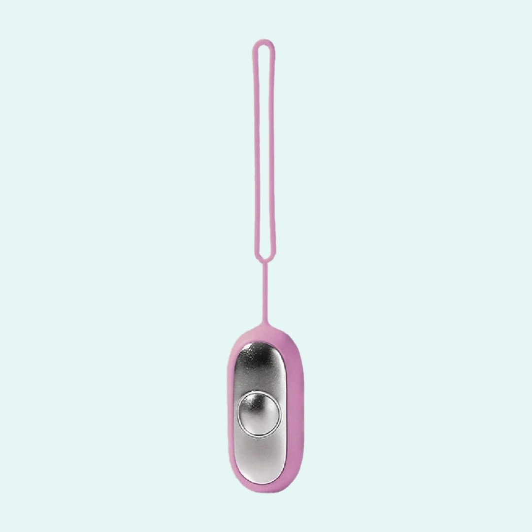 Palm Calm Fidget in Pink: mirror polished silver faceplate, one domed button, pink silicone shell and loop