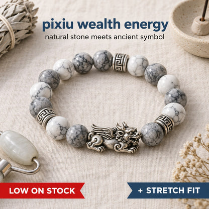 The Pomence Pixiu Wealth Bracelet flat lay, showing the white and grey turquoise beads, the Pixiu charm and the Greek key spacers