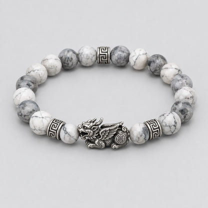 The Pomence Pixiu Wealth Bracelet alone on a plain pale grey background, coiled with the Pixiu charm at the front