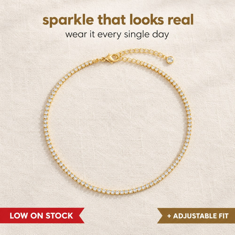 The Pomence Tennis Necklace laid out flat, a continuous row of 2mm round cubic zirconia stones in gold plated four prong settings