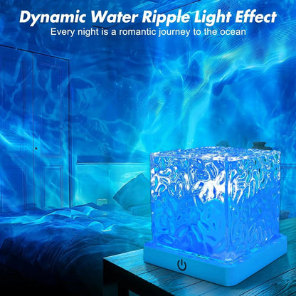 The crystal cube lamp glowing blue on a bedside table with ripples on the wall