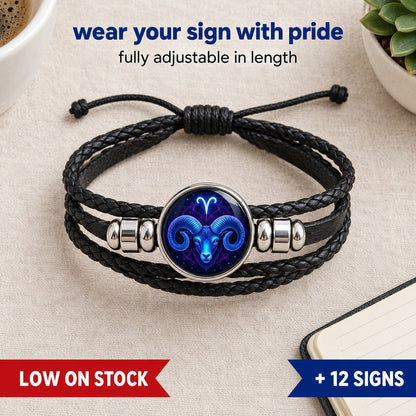 The Pomence Zodiac Leather Bracelet in a flat lay, showing the two braided leather cords, the flat strap, the glass zodiac dome and the two polished silver-tone barrel beads