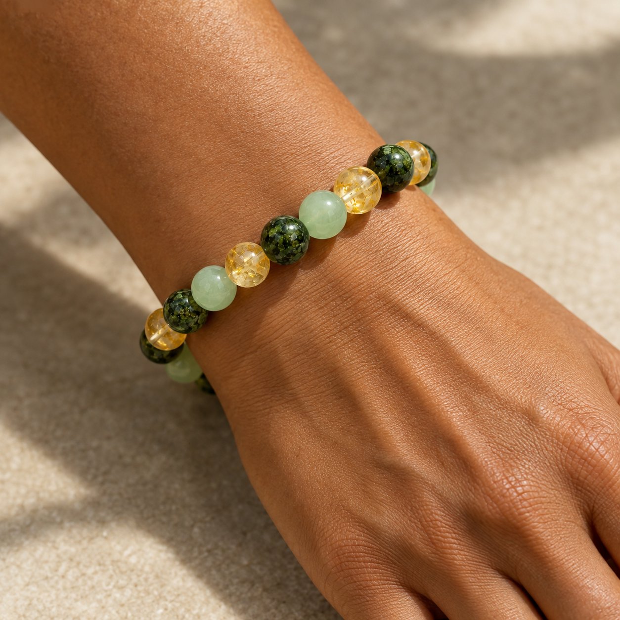 The Pomence Three Stone Abundance Bracelet worn on a wrist, the citrine, green aventurine and African turquoise beads repeating in order