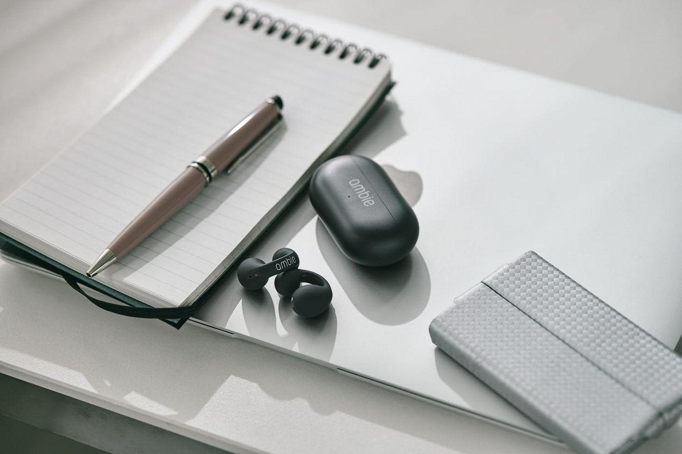 Ambie earcuffs and case on a desk