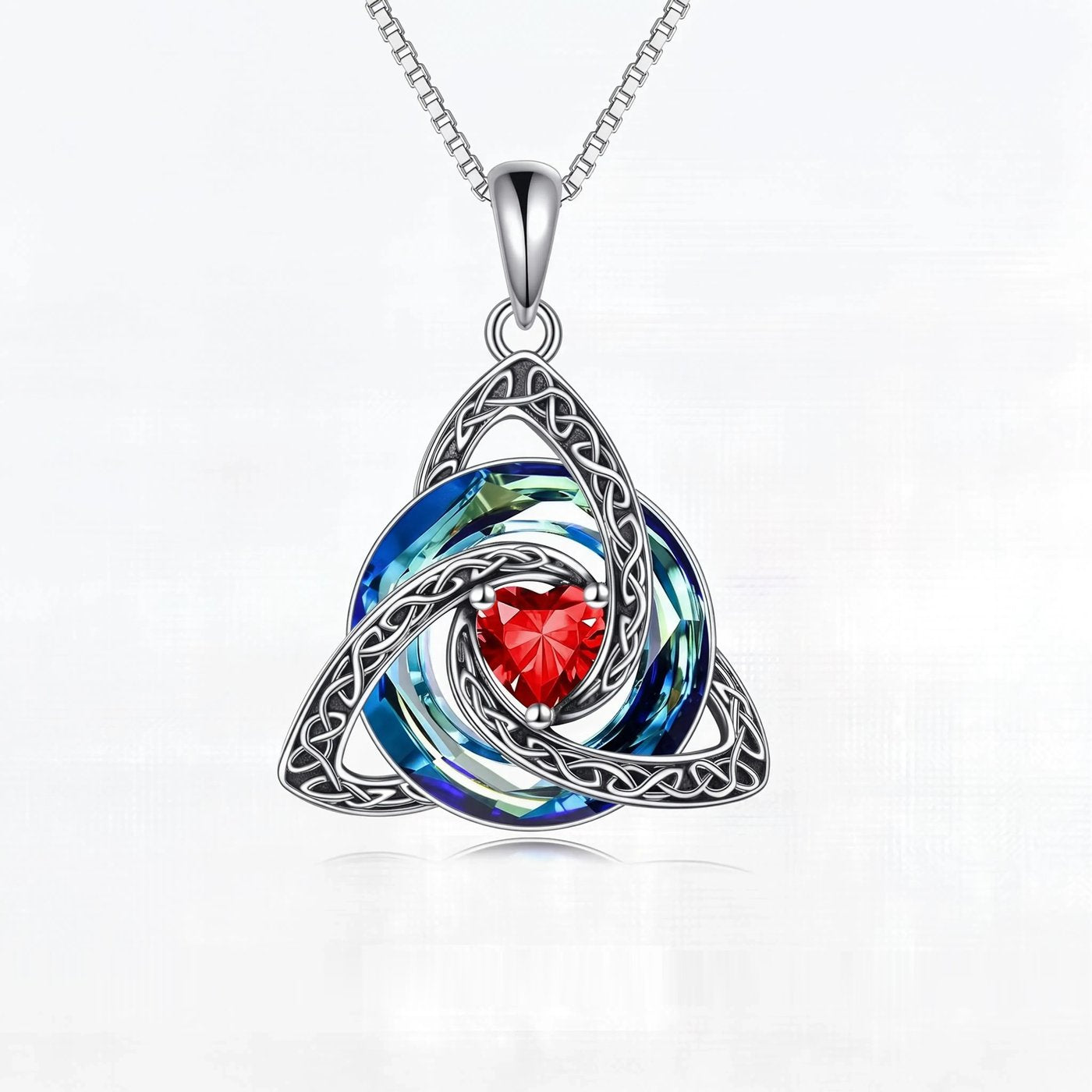 The Celtic knot pendant on its fine silver tone chain, shown against a plain ground for scale