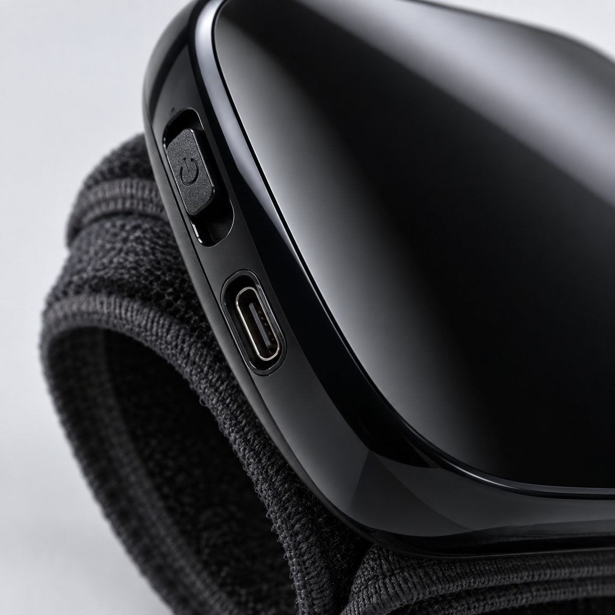 Macro of the left edge of the Pomence wrist blood pressure monitor showing the power switch and the charging port