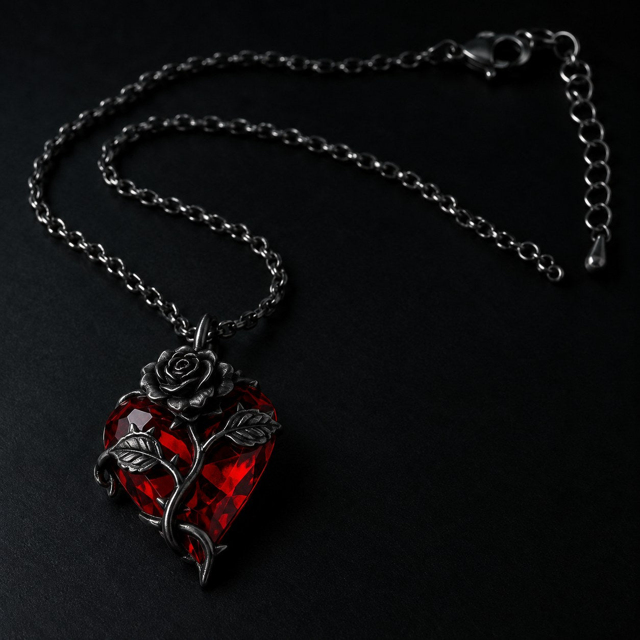 Macro detail of the fine gunmetal cable chain, lobster clasp and extender tail of the Pomence Blood Rose Necklace