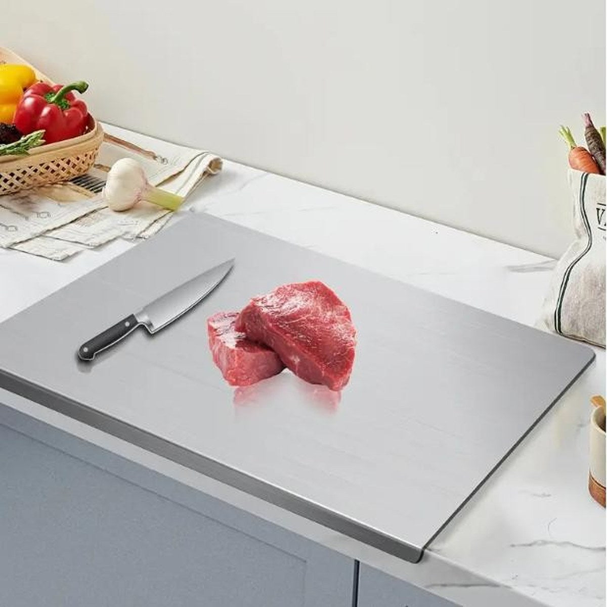 Raw steak being carved on the Pomence Stainless Steel Chopping Board