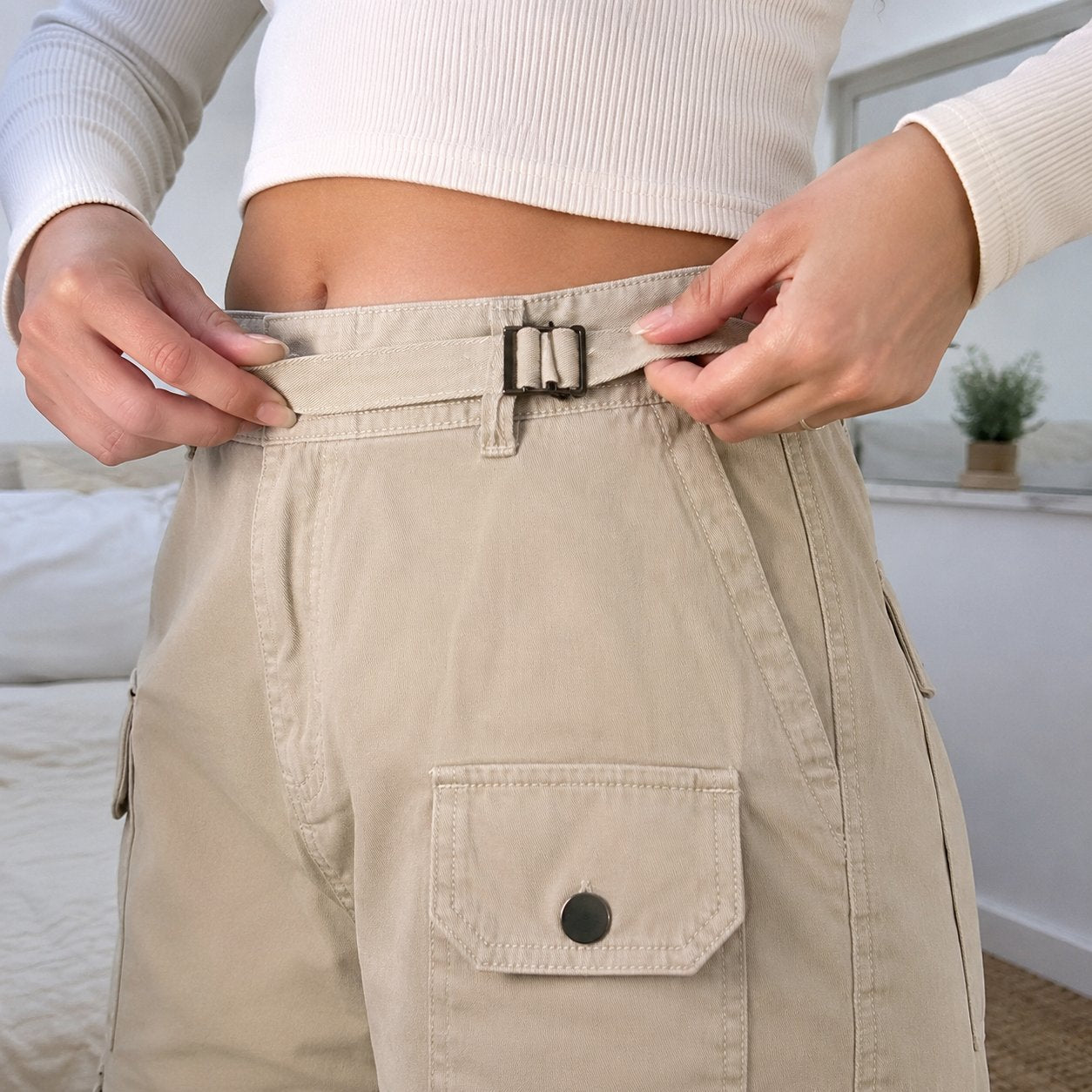 Hands tightening the built-in belt through its metal buckle