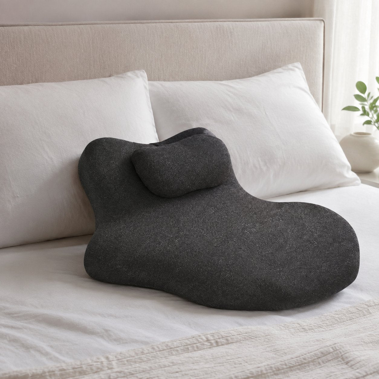 Pomence Couples Comfort Pillow resting on a made bed with other pillows