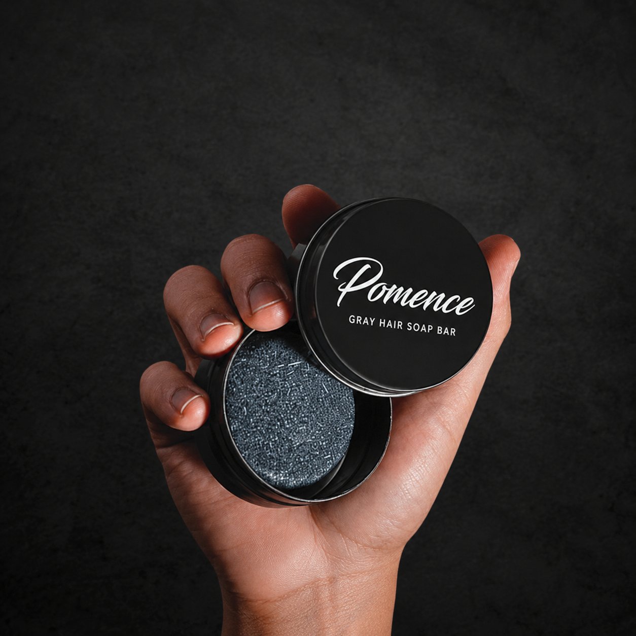 Close-up of the speckled Pomence Gray Hair Soap Bar and its tin