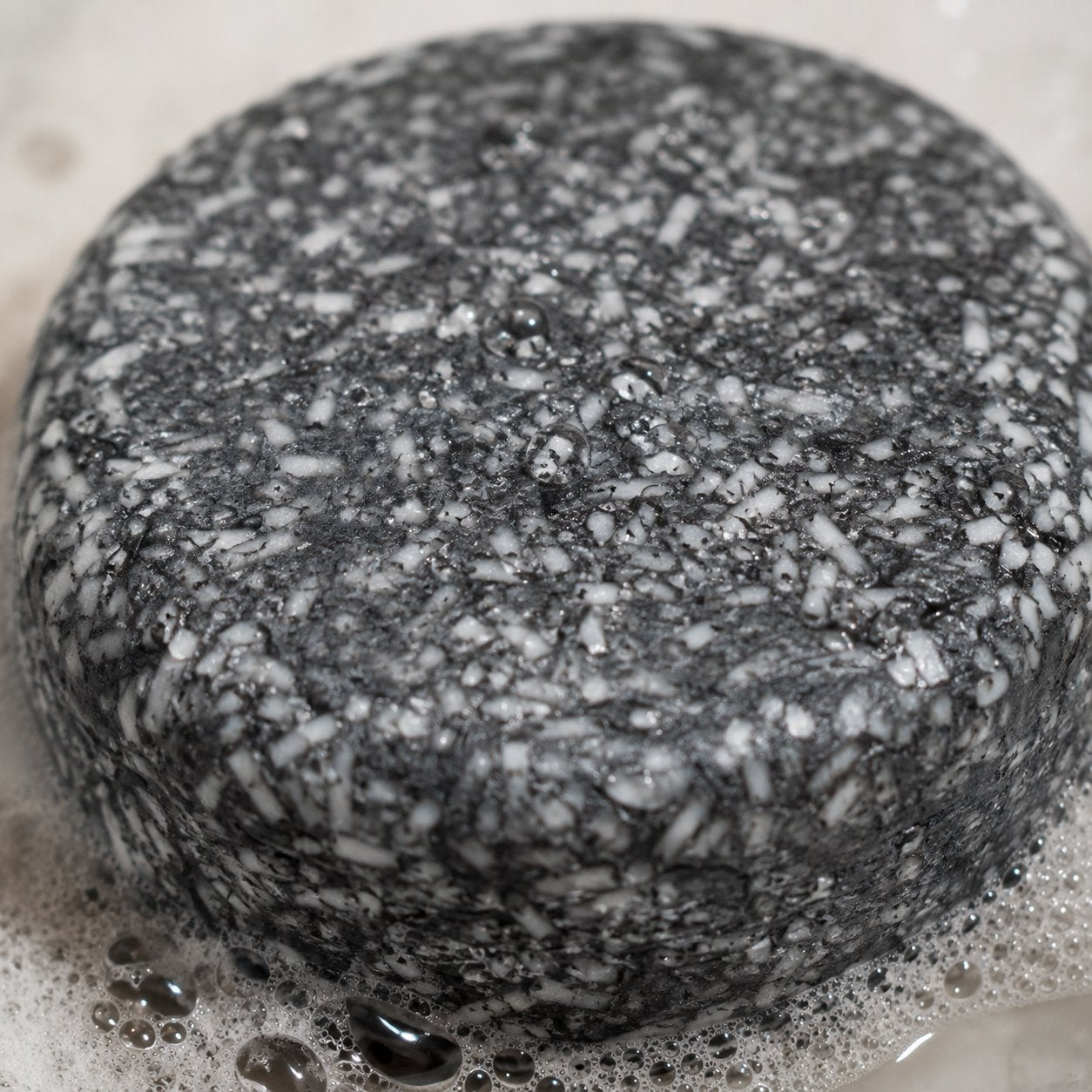Macro close-up of the bamboo charcoal texture in the Pomence Gray Hair Soap Bar