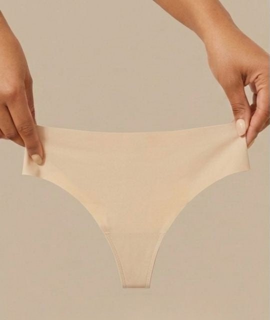 Two hands stretching the Pomence Invisible No-Show Thong in Sand to show its 4-way stretch