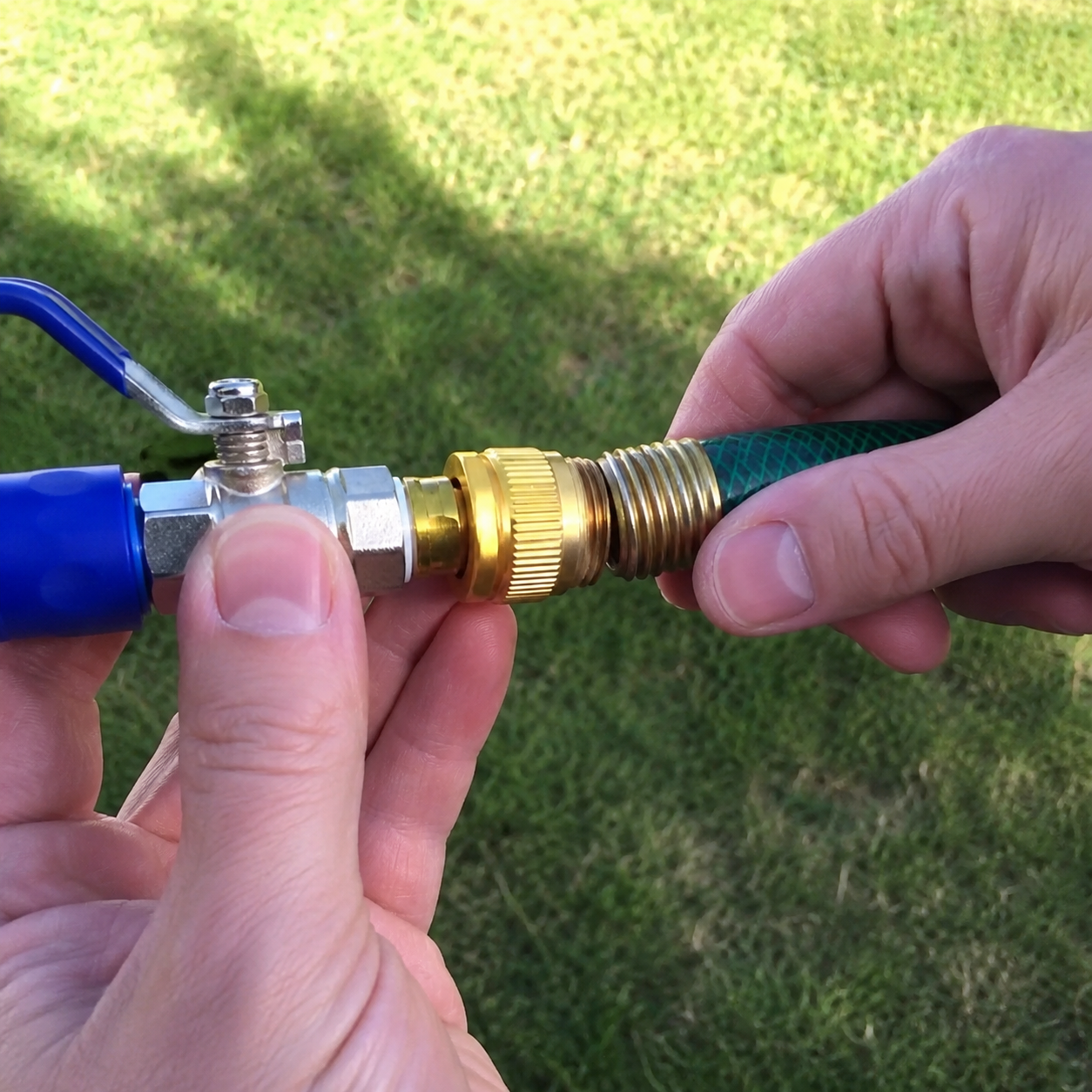 JetHose brass fitting being twisted onto a garden hose