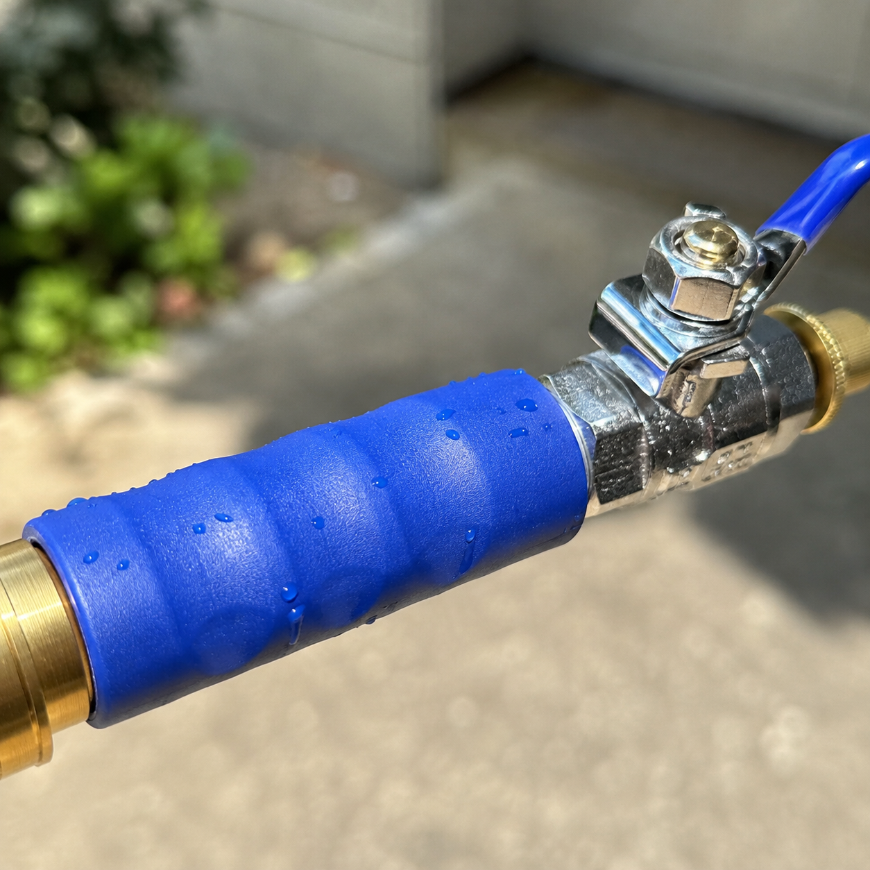 Close macro of the JetHose brass valve and blue grip