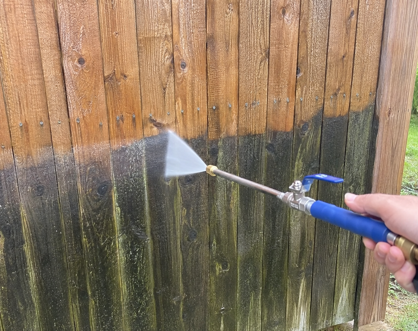 JetHose cleaning green mould off a wooden fence panel